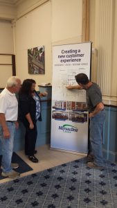 Construction worker showing Bank employees the Natick office renovation floor plan