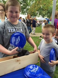 Boy holding MutualOne Bank frisbee at Natick Days