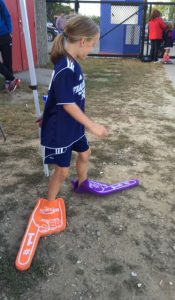 Little girl using foam fingers as shoes