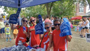 Tweens wearing foam fingers at MutualOne Bank's booth at Natick Days