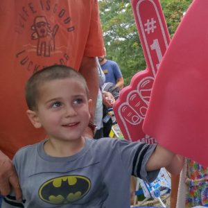 Young boy wearing foam fingers at MutualOne Bank's booth at Natick Days