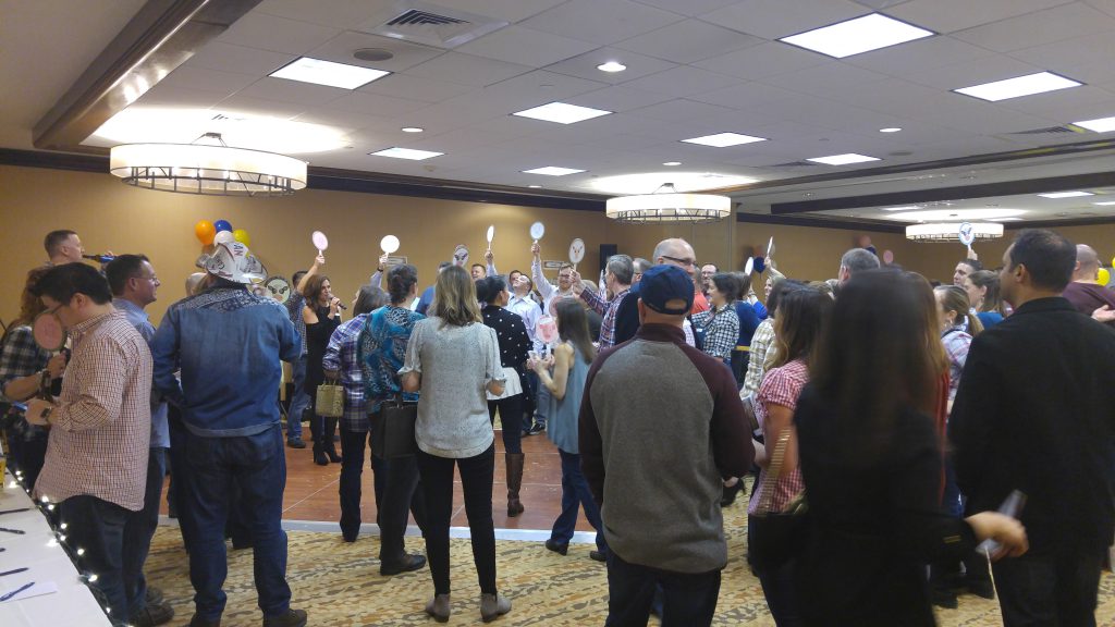 Attendees at "State Fair" event participating in auction