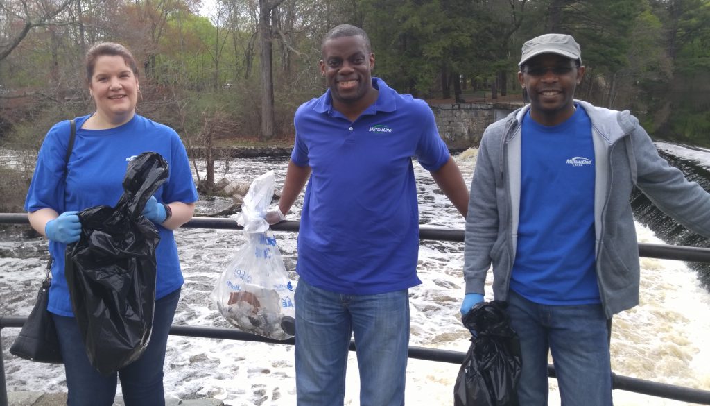 MutualOne Bank Employees in front of Charles River holding trash bags