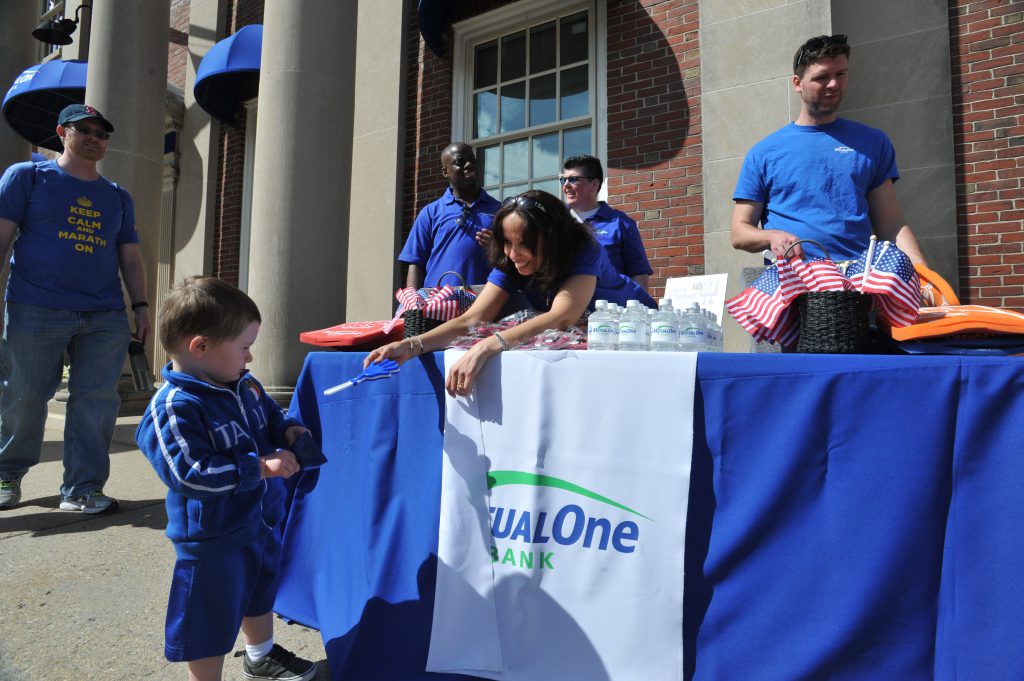 MutualOne Bank employee handing giveaway to young boy