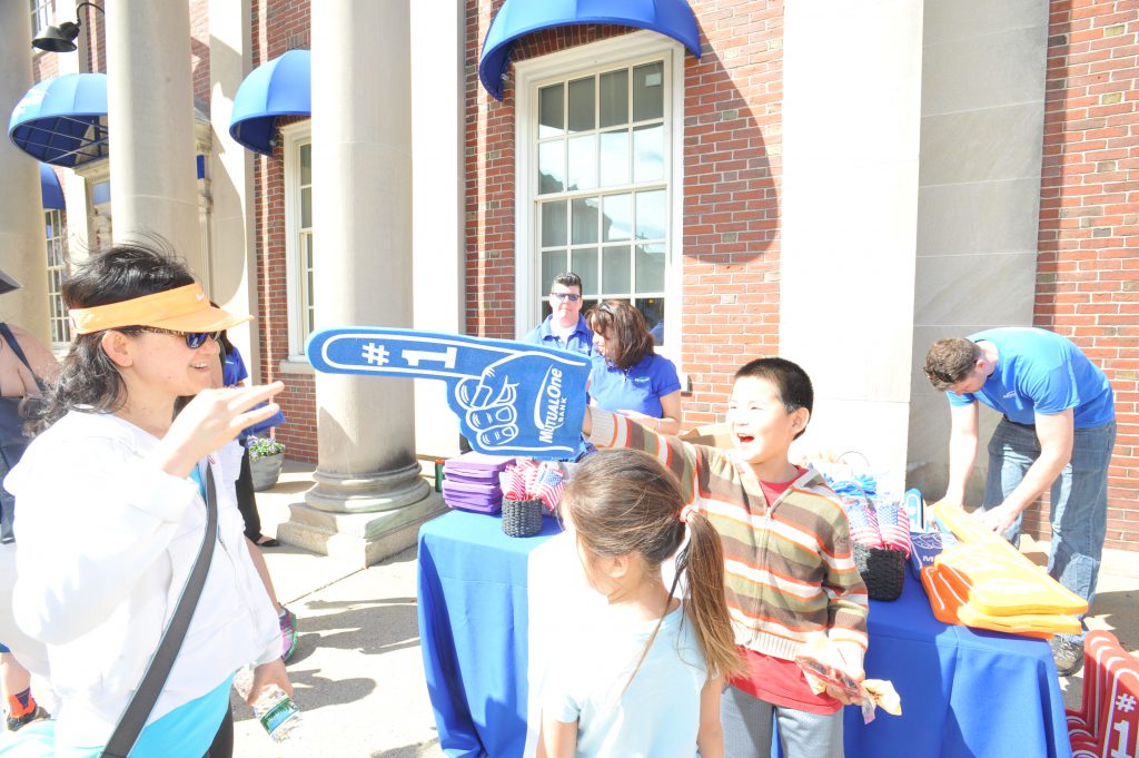 Family enjoying foam finger giveaway in front of MutualOne Bank