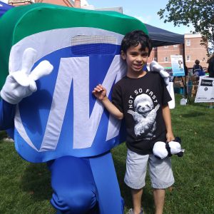 Natick Days Mo with boy giving peace sign