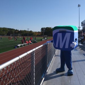 Mo standing watching the soccer game