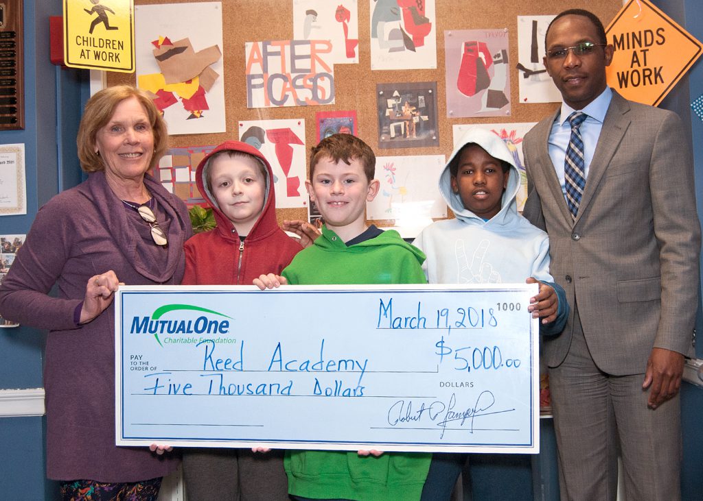 Reed Academy Executive Director Mary Crawford; MutualOne Bank Charitable Foundation Administrator Yves Munyankindi and Reed Academy students Nick Grant, Alex Williams and Henry Barry celebrate the Foundation’s recent $5,000 award.