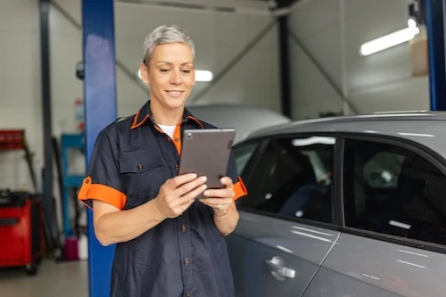 Car mechanic looking at tablet