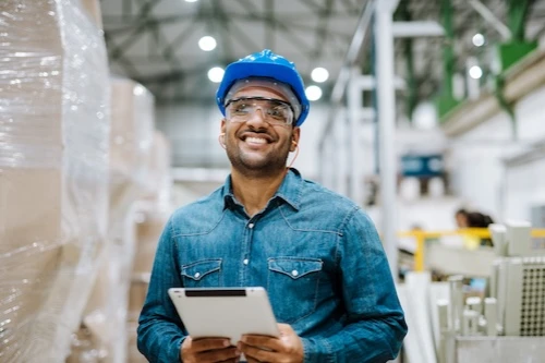 Man in warehouse wearing a hard hat