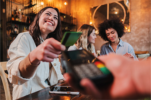 Three friends paying for lunch with credit card.