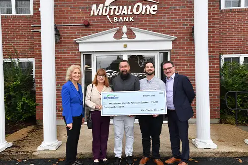 5 people standing and holding a big check.